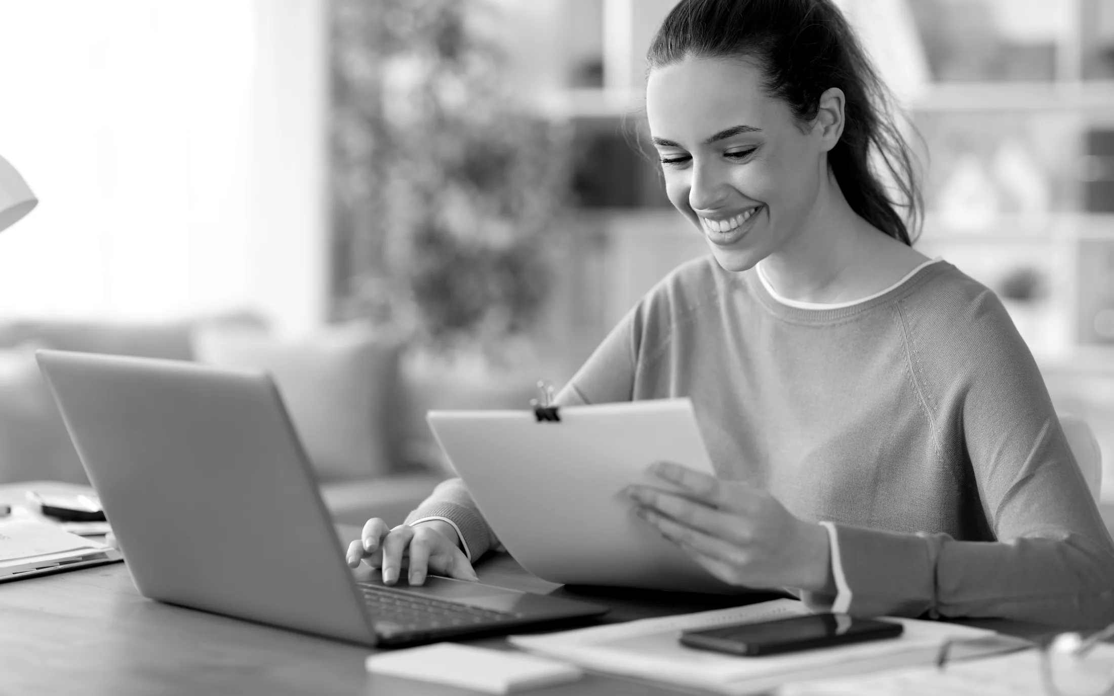 Black-and-white laptop and documentation workspace